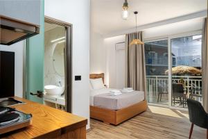a room with a bed and a bathroom with a balcony at Amoudi Studios Apartments Hotel in Amoudi