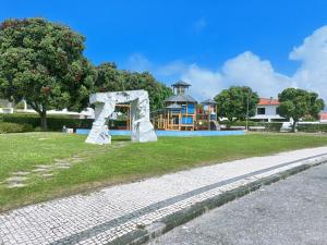 een speeltuin in een park met een wit beeld bij Moradia praia de Esposende in Marinhas