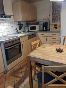 a kitchen with a wooden table and a kitchen with a stove and oven at Ferienhaus 3 Eulen in Kurort Altenberg