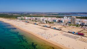 an aerial view of a beach with a group of people at 1BDR Apartment W/Beach View by LovelyStay in Monte Gordo
