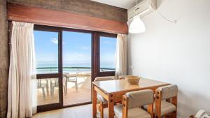 - une salle à manger avec une table et une vue sur l'océan dans l'établissement 1BDR Apartment W/Beach View by LovelyStay, à Monte Gordo