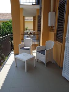 a patio with two chairs and a table on a balcony at Da Peppino e Nicchella in Marina di Camerota