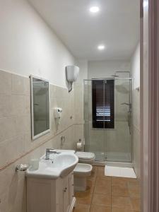 uma casa de banho com um lavatório, um chuveiro e um WC. em Da Peppino e Nicchella em Marina di Camerota