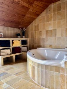 a bath tub in a bathroom with a wooden ceiling at Altmühl Familienvilla in Treuchtlingen