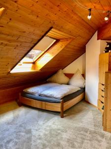 a bed in a room with a wooden ceiling at Altmühl Familienvilla in Treuchtlingen