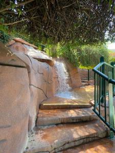 a waterfall in a park with stairs and a fence at SPAZZIO DI ROMA INCLUSO ACQUA PARK SPLASH in Caldas Novas