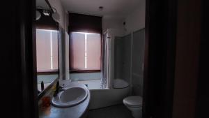 een badkamer met een wastafel, een toilet en een raam bij Casa vacanze Andrea in Cattolica