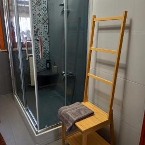 a bathroom with a shower with a towel on a chair at HOME Lagana' in Messina