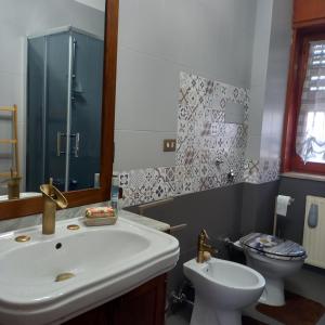 a bathroom with a sink and a toilet at HOME Lagana' in Messina
