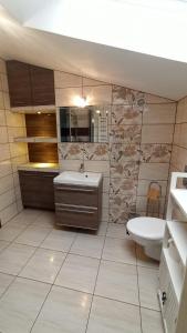 uma casa de banho com um lavatório, uma banheira e um WC. em Apartament "Na szlaku" em Ostrowo