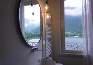 La salle de bains est pourvue d'un miroir, d'un lavabo et d'une fenêtre. dans l'établissement Locanda alla Grotta, à Crone