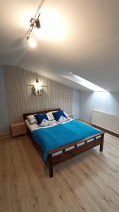 a bedroom with a large bed with a blue blanket at Apartament "Na szlaku" in Ostrowo