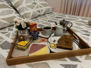uma bandeja de comida de pequeno-almoço numa cama em New York Suites em Viña del Mar
