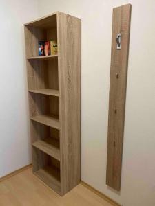a wooden book shelf in the corner of a room at Ferienwohnung mit Terrasse Nähe Bayreuth in Heinersreuth