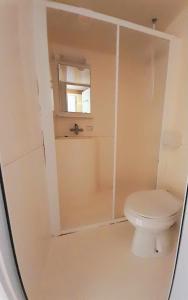 La salle de bains blanche est pourvue d'une douche et de toilettes. dans l'établissement Les Auzerals camping du lac, à Rabastens