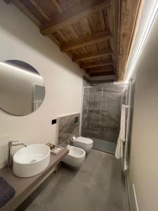 a bathroom with two sinks and a toilet and a mirror at La Dimora del Brocante in Cuneo