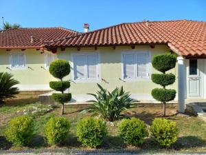 a house with a bunch of bushes in front of it at Апартаменты Вилла Ионика in Kalón Nerón