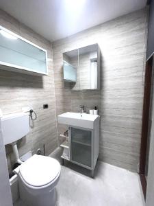 een badkamer met een toilet, een wastafel en een spiegel bij gler_house in Ischia