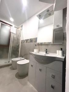 een witte badkamer met een toilet en een wastafel bij gler_house in Ischia