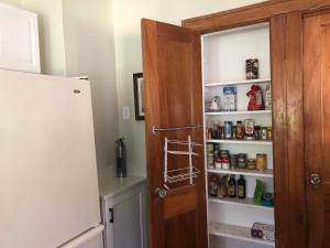 a kitchen with an open pantry door and a refrigerator at Seabreeze Three Bedroom Home in Rochester