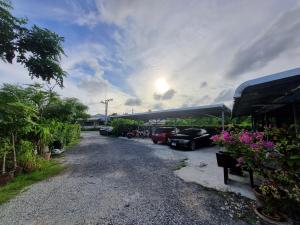 a gravel driveway with cars parked in a parking lot at Bests Village & Villa - Chalong Bay Phuket in Chalong