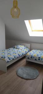 OutreauにあるLe Sunny-Appartement duplex spacieuxのベッドルーム1室(ベッド2台、ラグ、窓付)