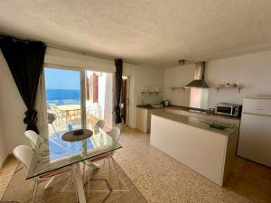 a kitchen with a glass table and a view of the ocean at Apartamento Luz ZM109 in Benitachell