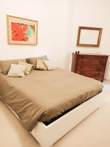ein weißes Schlafzimmer mit einem großen Bett und einer Kommode in der Unterkunft Interno 3 - vicino al mare e pista ciclabile, centro zona Foce in Sanremo