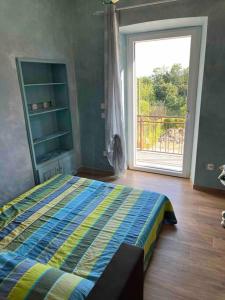 a bedroom with a bed and a large window at Al Buffardel in Bagnone