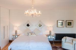 una camera da letto con un grande letto bianco e un lampadario a braccio di Leverhulme Hotel a Port Sunlight