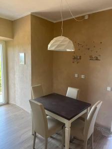 a dining room with a black table and white chairs at Al Buffardel in Bagnone