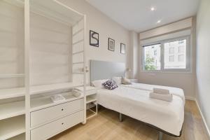 a white bedroom with a bed and a window at Apartamento Pamplona Prime by Clabao in Pamplona