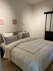 1 dormitorio con 1 cama grande con sábanas blancas en Le loft du Castel Mosan, en Namur