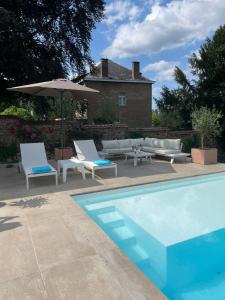a pool with two lounge chairs and an umbrella at Le loft du Castel Mosan in Namur