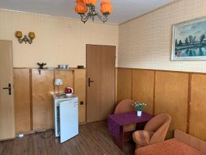 Cette chambre comprend un réfrigérateur, une table et des chaises. dans l'établissement Noclegi Paradise, à Darłówko