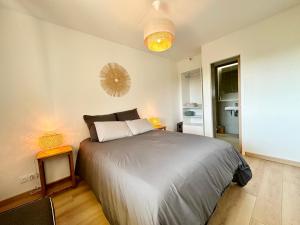 una camera da letto con un letto e uno specchio a parete di T2 refait à neuf – À 2 pas du bourg et des plages a Larmor-Plage