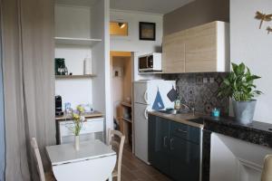 a small kitchen with a white refrigerator and a table at Le petit Orléanais in Orléans