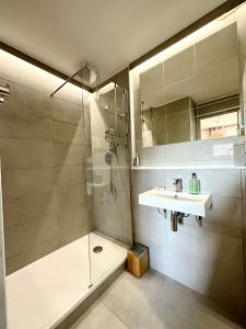 La salle de bains est pourvue d'une douche et d'un lavabo. dans l'établissement T2 refait à neuf – À 2 pas du bourg et des plages, à Larmor-Plage