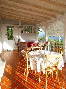 una sala da pranzo con tavolo e sedie su un portico di Beausejour Guest House a Pointe-Noire