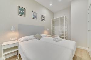 a white bedroom with a large bed and a desk at Apartamento Pamplona Prime by Clabao in Pamplona