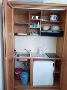 una cucina con lavandino e mensola con stoviglie di La pecorella in vacanza IUN R3384 a Pula