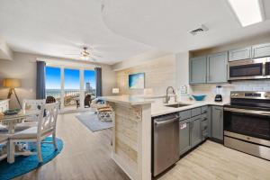 a kitchen and dining room with a view of the ocean at Calypso Tower 3 - Endless Sunsets and Gulf Coast View! in Panama City Beach