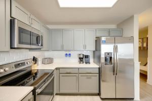 a kitchen with white cabinets and a stainless steel refrigerator at Calypso Tower 3 - Endless Sunsets and Gulf Coast View! in Panama City Beach