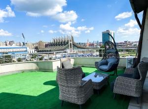 a balcony with chairs and a table and a view of a city at Swiss Apartments Prishtina in Pristina