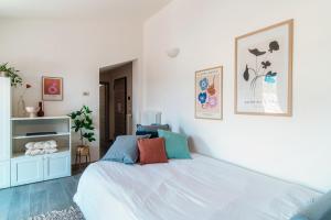 a bedroom with a large white bed with colorful pillows at Bonanomi Como by Quokka 360 - Terrace Duomo View in Como