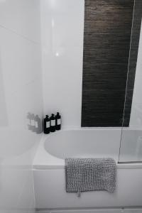 La salle de bains est pourvue d'une douche et de 2 bouteilles noires. dans l'établissement Central Charm Stunning 1 Bedroom apartment Sleeps 4, à Sheffield