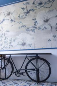 ein Fahrrad wird neben einer Wand mit einem Gemälde geparkt in der Unterkunft Locanda alla Grotta in Crone