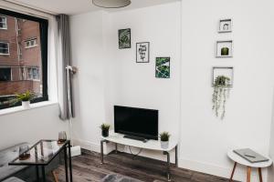 ein Wohnzimmer mit einem Flachbild-TV an einer weißen Wand in der Unterkunft Central Charm Stunning 1 Bedroom apartment Sleeps 4 in Sheffield