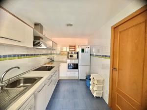 a kitchen with white appliances and a wooden door at Apartamentos Boutique Terrazas in Oropesa del Mar