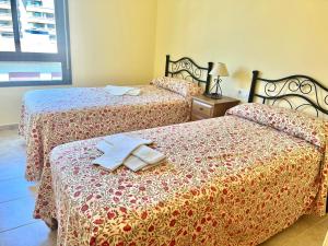 two beds sitting next to each other in a bedroom at Apartamentos Boutique Terrazas in Oropesa del Mar